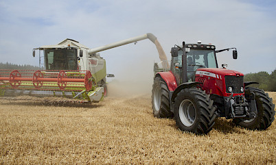 Mähdrescher belädt einen Traktor mit Getreide
